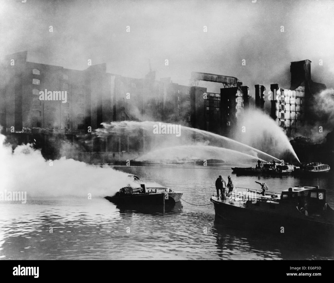 Londra per i vigili del fuoco diretto di acqua dal loro fireboats su blazing magazzino. I tedeschi hanno bombardato le strutture portuali in Londra Foto Stock