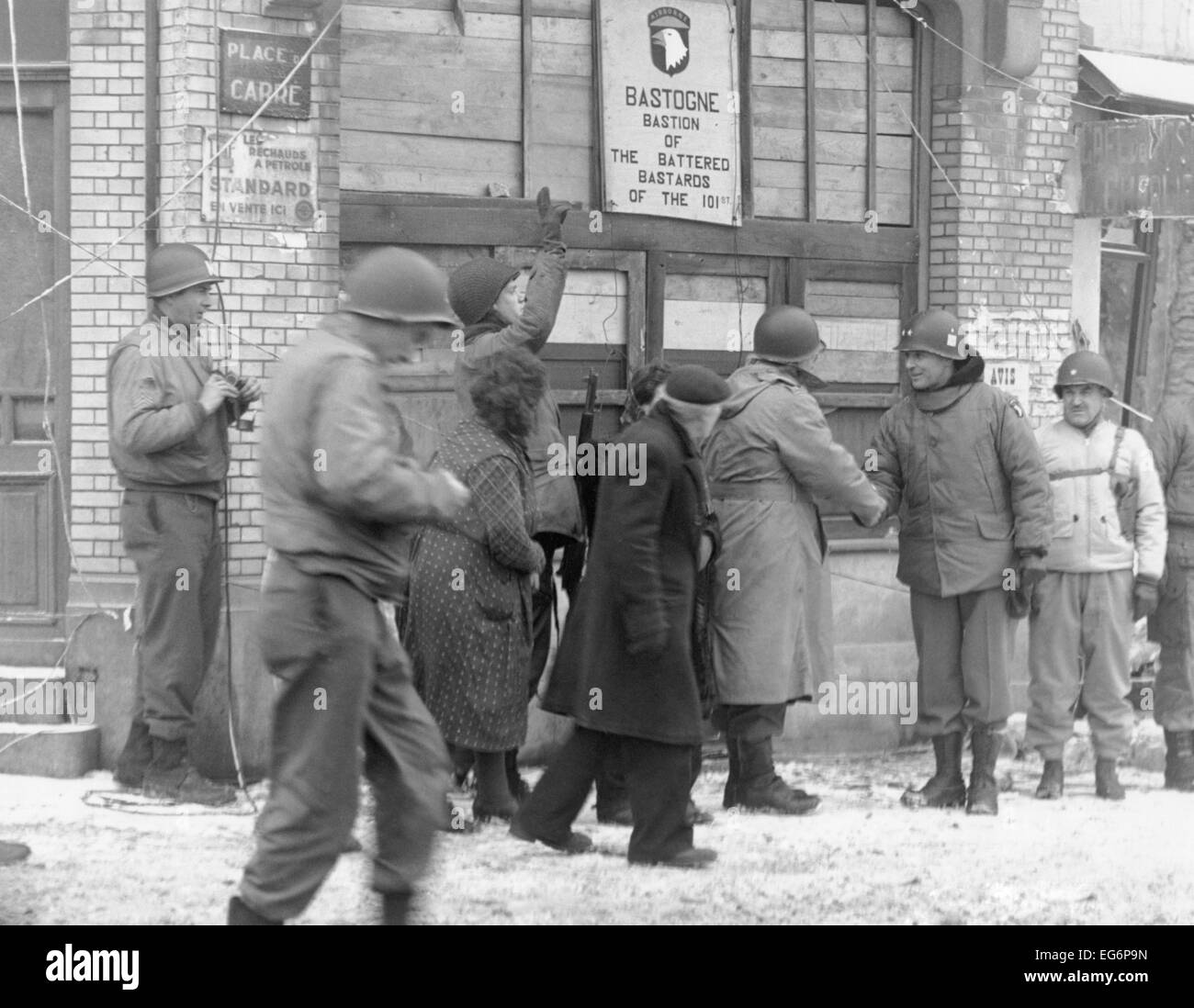 Personale militare degli Stati Uniti rivisitazione di Bastogne, Belgio, sei anni dopo la battaglia di Bulge. Il gruppo si riunisce sotto un segno Foto Stock