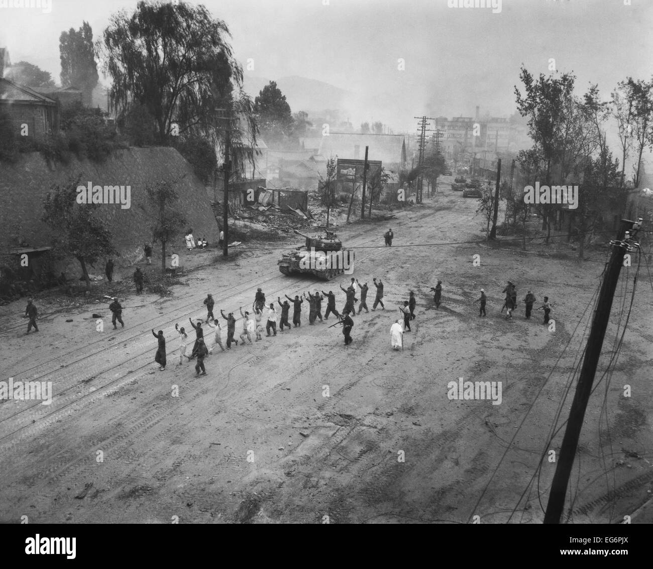 Stati Uniti Acquario marino segue una linea di prigionieri di guerra in fondo a una strada. Sett. 26, 1950. Probabilmente vicino a Seul in Corea. Guerra di Corea, Foto Stock