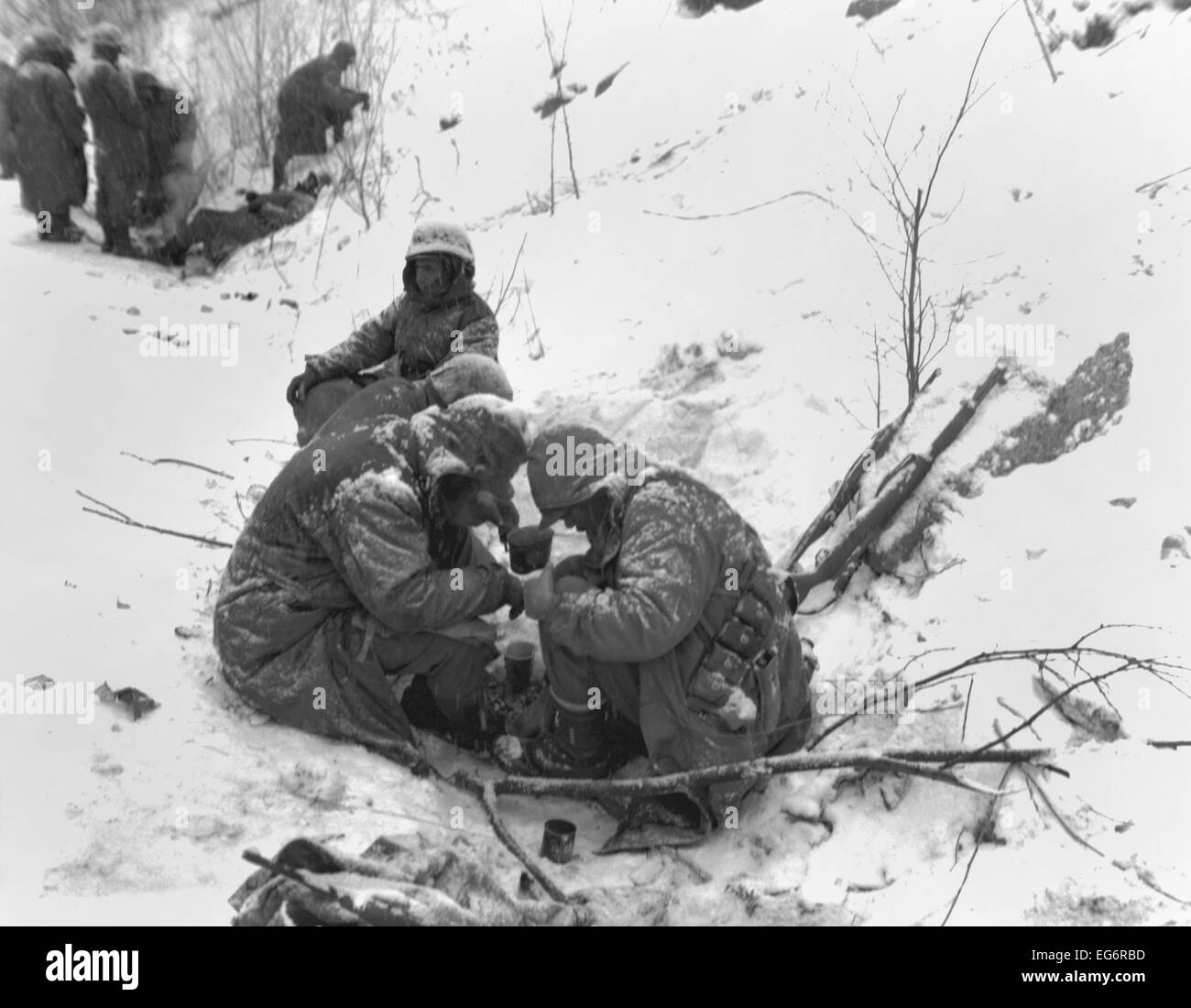 Marines esaurito dal loro cinque giorni e notti di battaglia con il cinese prendere un periodo di riposo con una bevanda calda. La loro quindici miglia Foto Stock