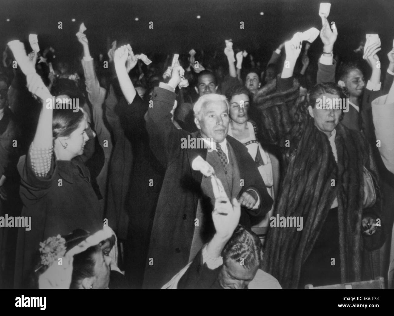 Charlie Chaplin con la moglie Oona a Hollywood Bowl campaign rally per Henry Wallace nel 1948. Il pubblico si holding dollar Foto Stock