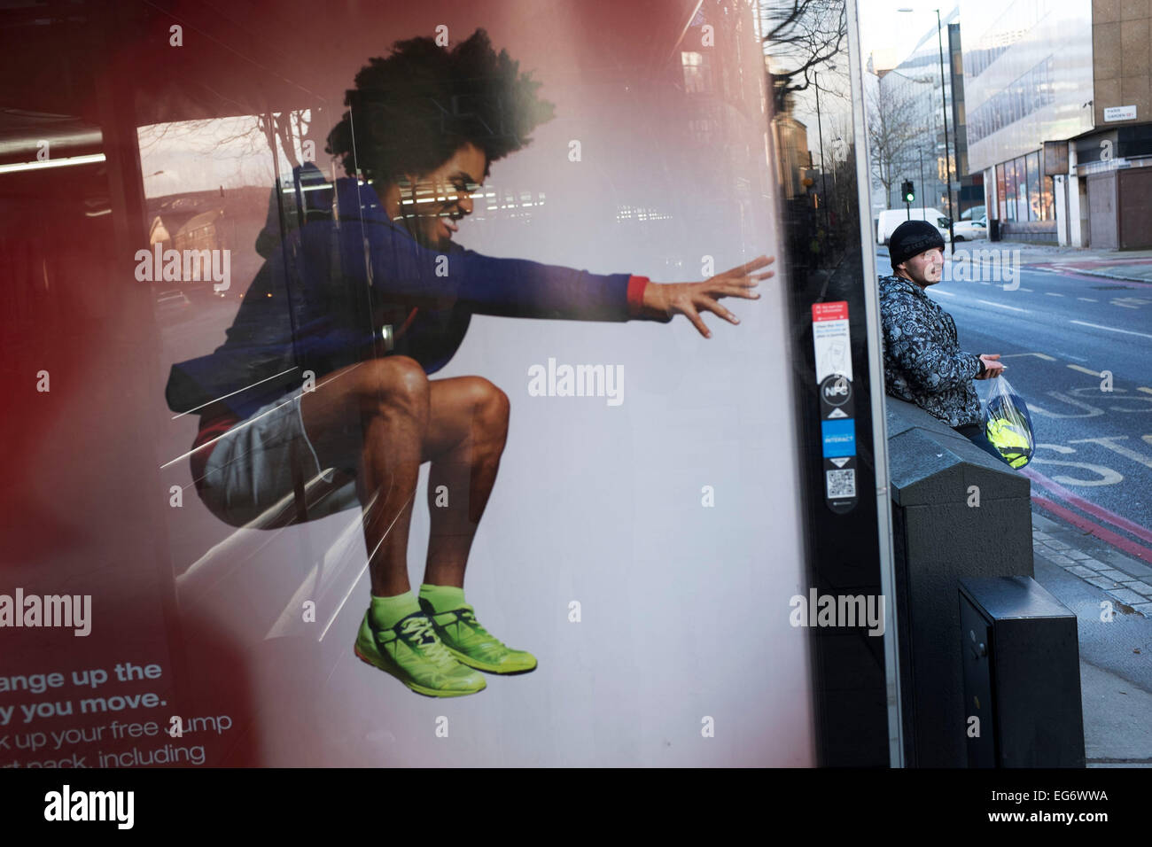 Jumping uomo su un poster pubblicitario interracts con un uomo sulla strada a Londra, Regno Unito. Foto Stock