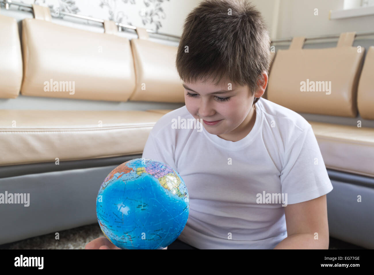 Ragazzo studiare globe in camera Foto Stock