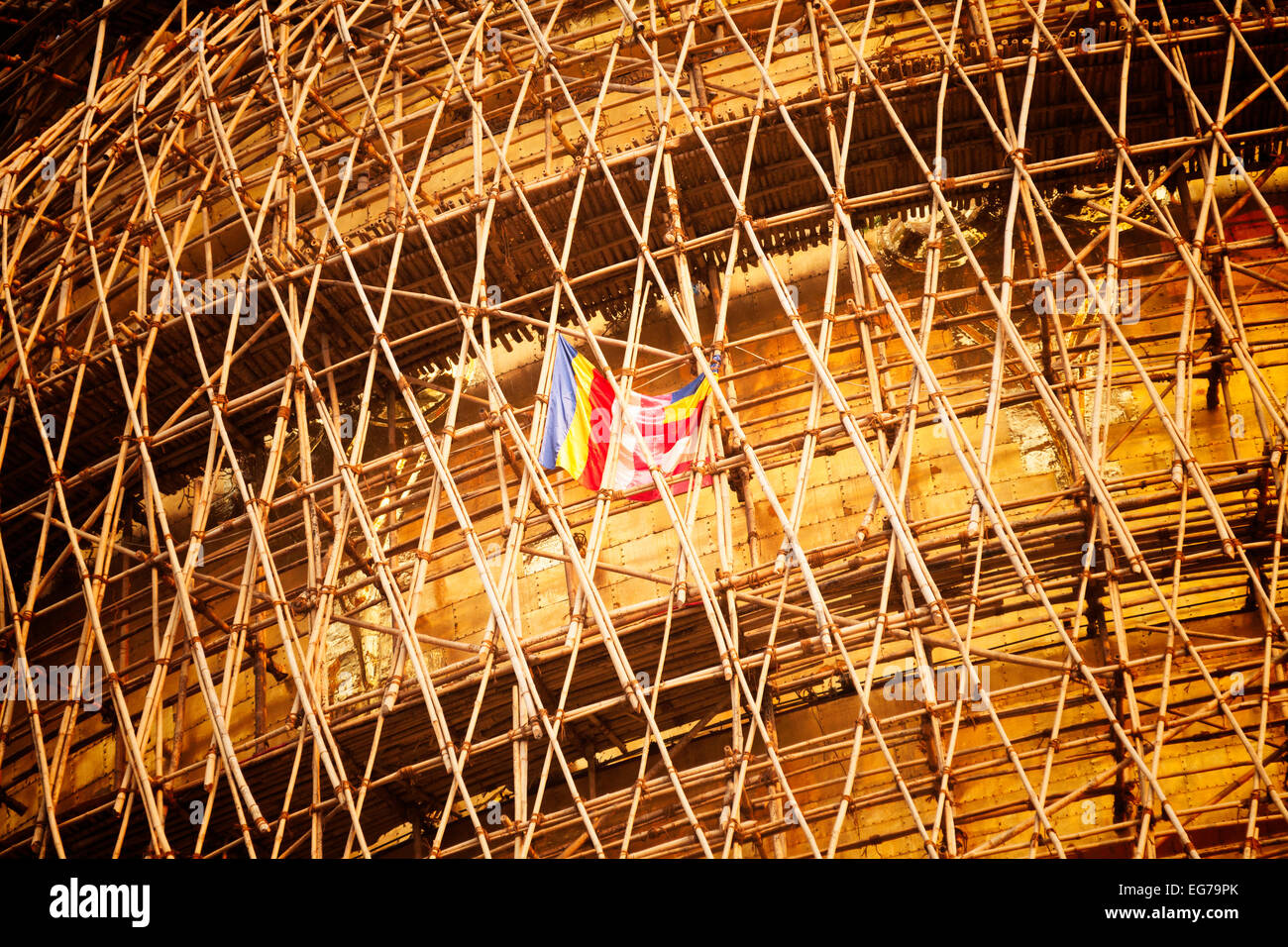 La bandiera buddista battenti in bamboo ponteggio sul Shwedagon pagoda durante il re-posa della foglia oro, Yangon, Myanmar Foto Stock