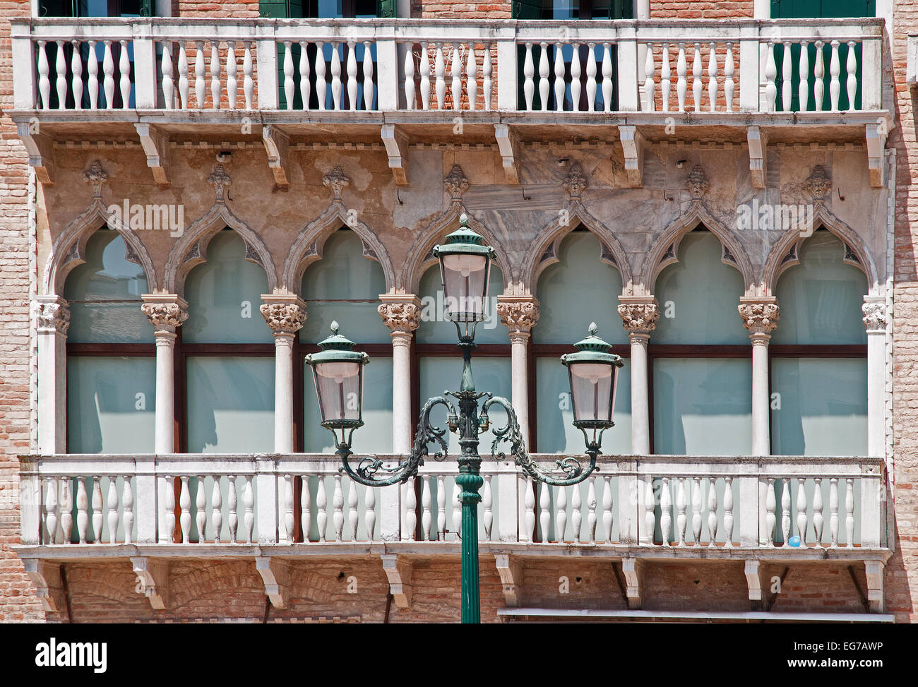 Elegante e tradizionale di verande o balconi di edifici in mattoni con elegante strada lampada stand in Campo San Stefano Venezia Italia B Foto Stock