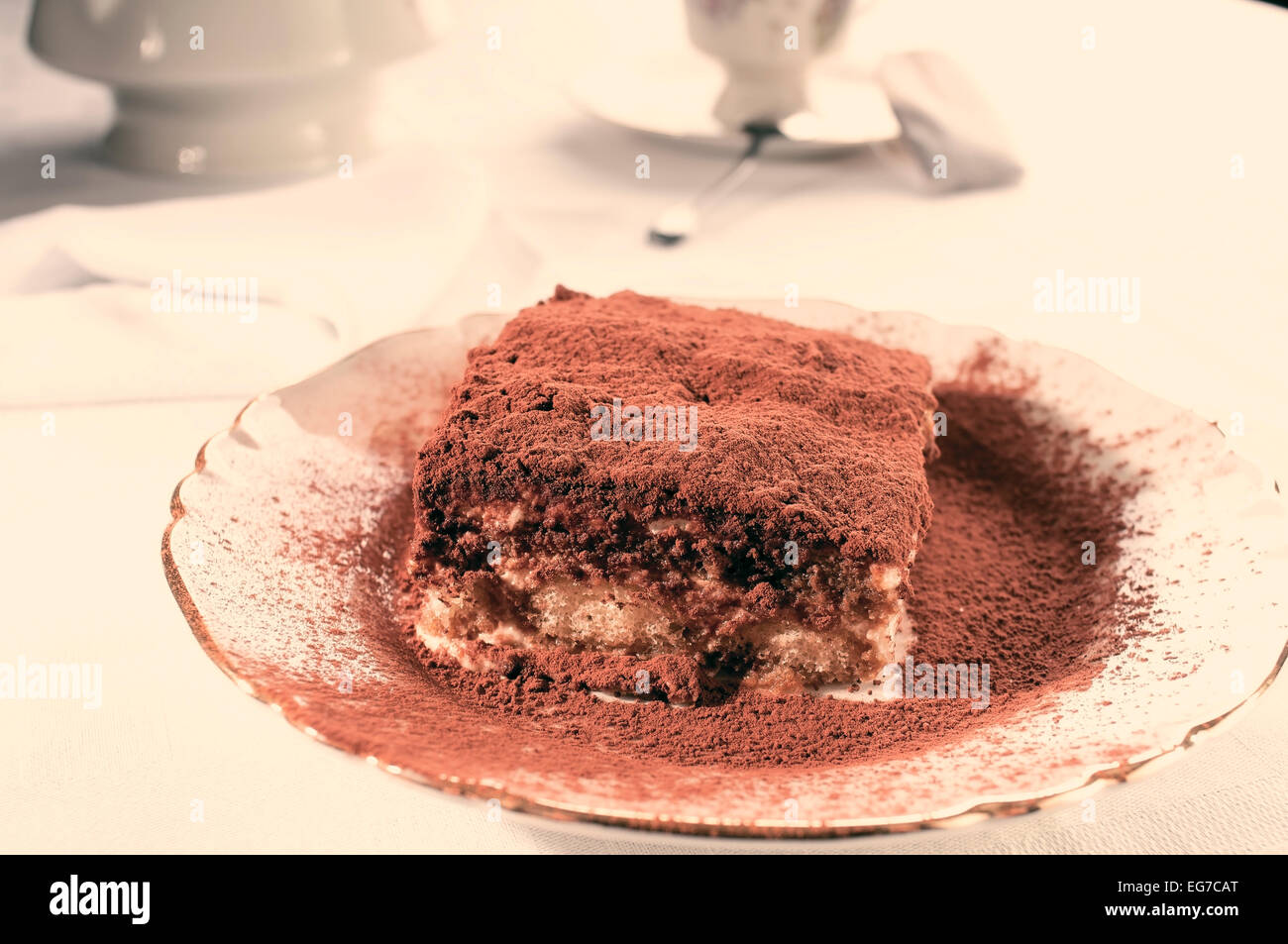 Fetta di fatti in casa tiramisù italiani dessert servito su una piastra in instagram tono caldo Foto Stock
