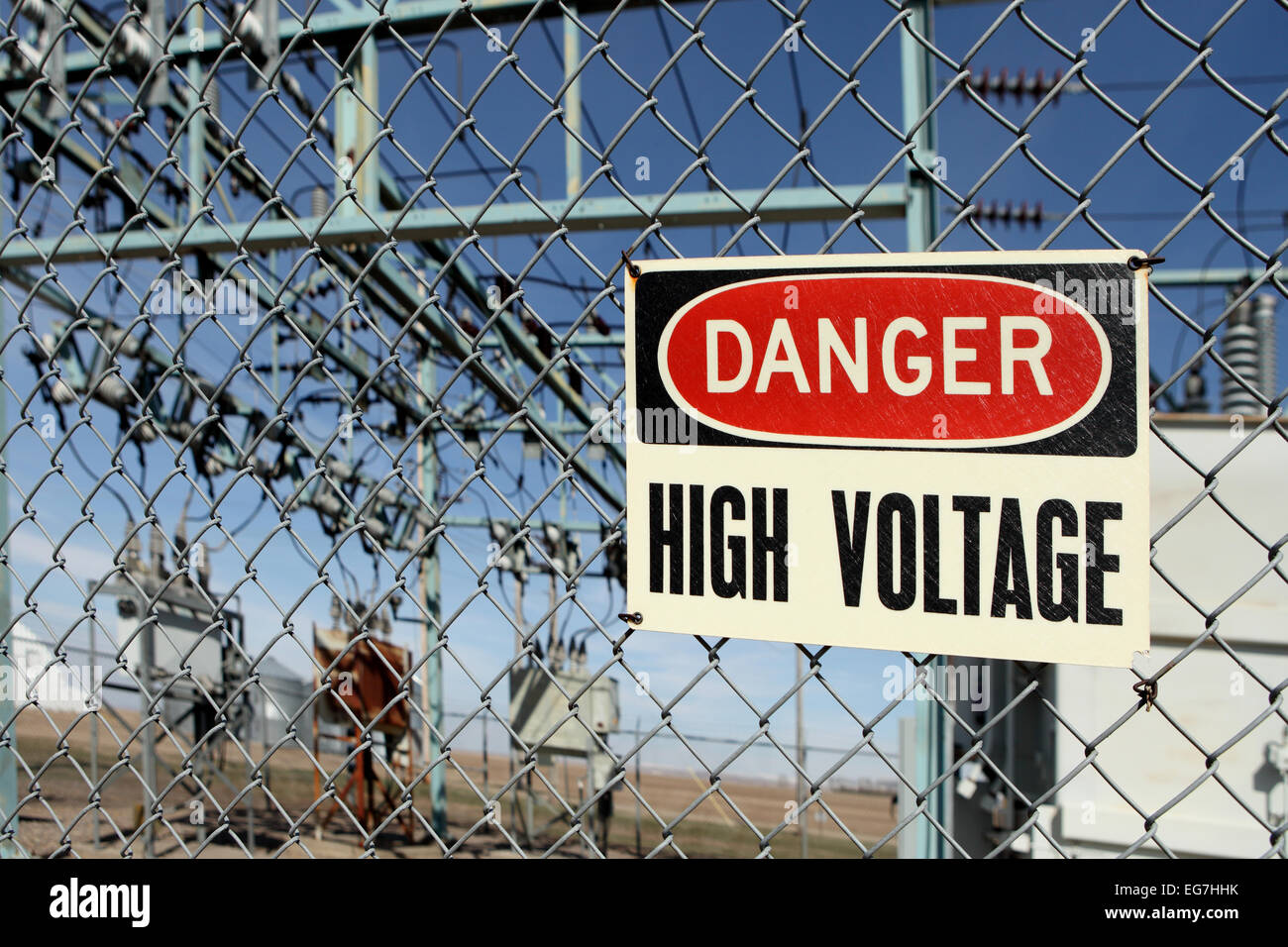 Un valore di tensione alto segnale di avvertimento sul recinto intorno a una sottostazione elettrica. Foto Stock