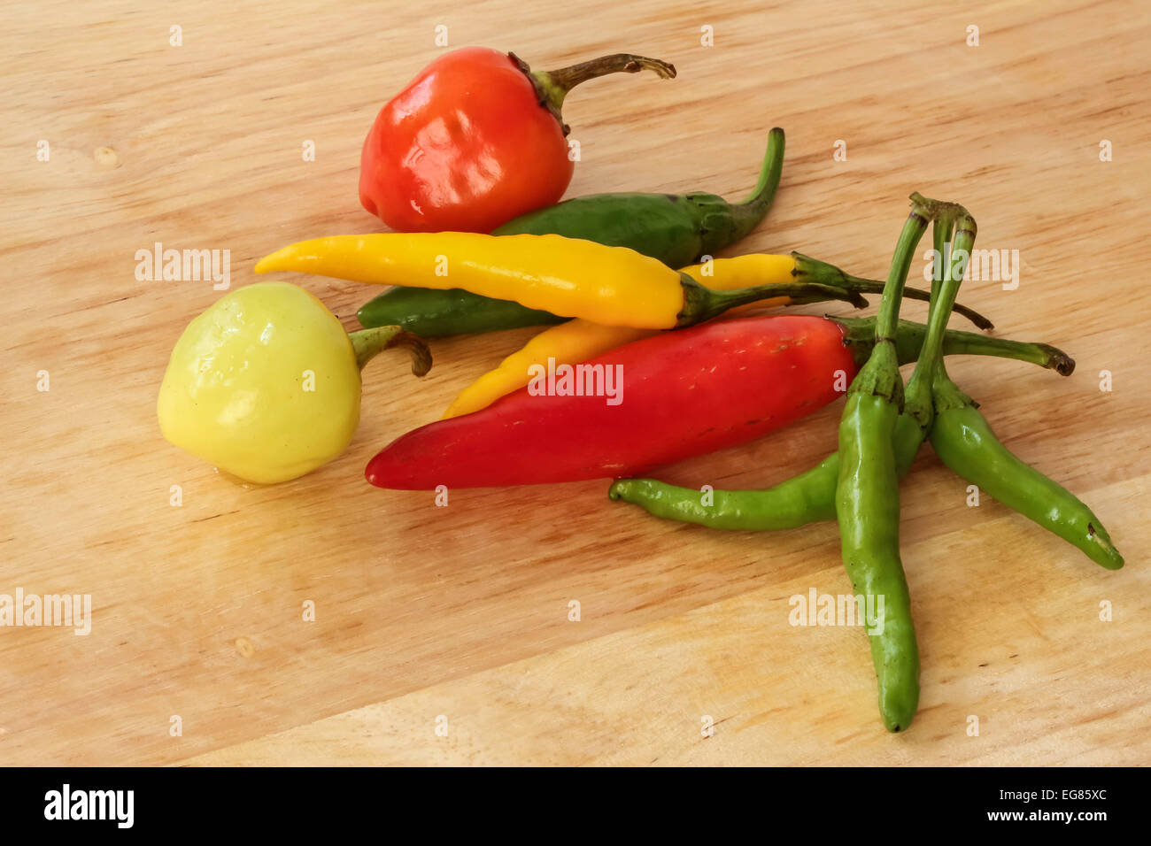 Colorato - peperoncino rosso, verde e giallo - Sfondo legno Foto Stock