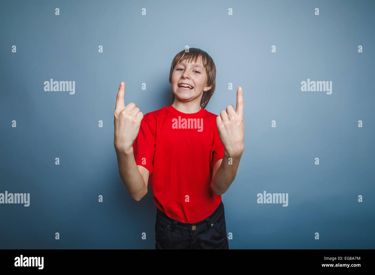 Ragazzo adolescente aspetto europeo in una maglietta rossa indica il numero Foto Stock