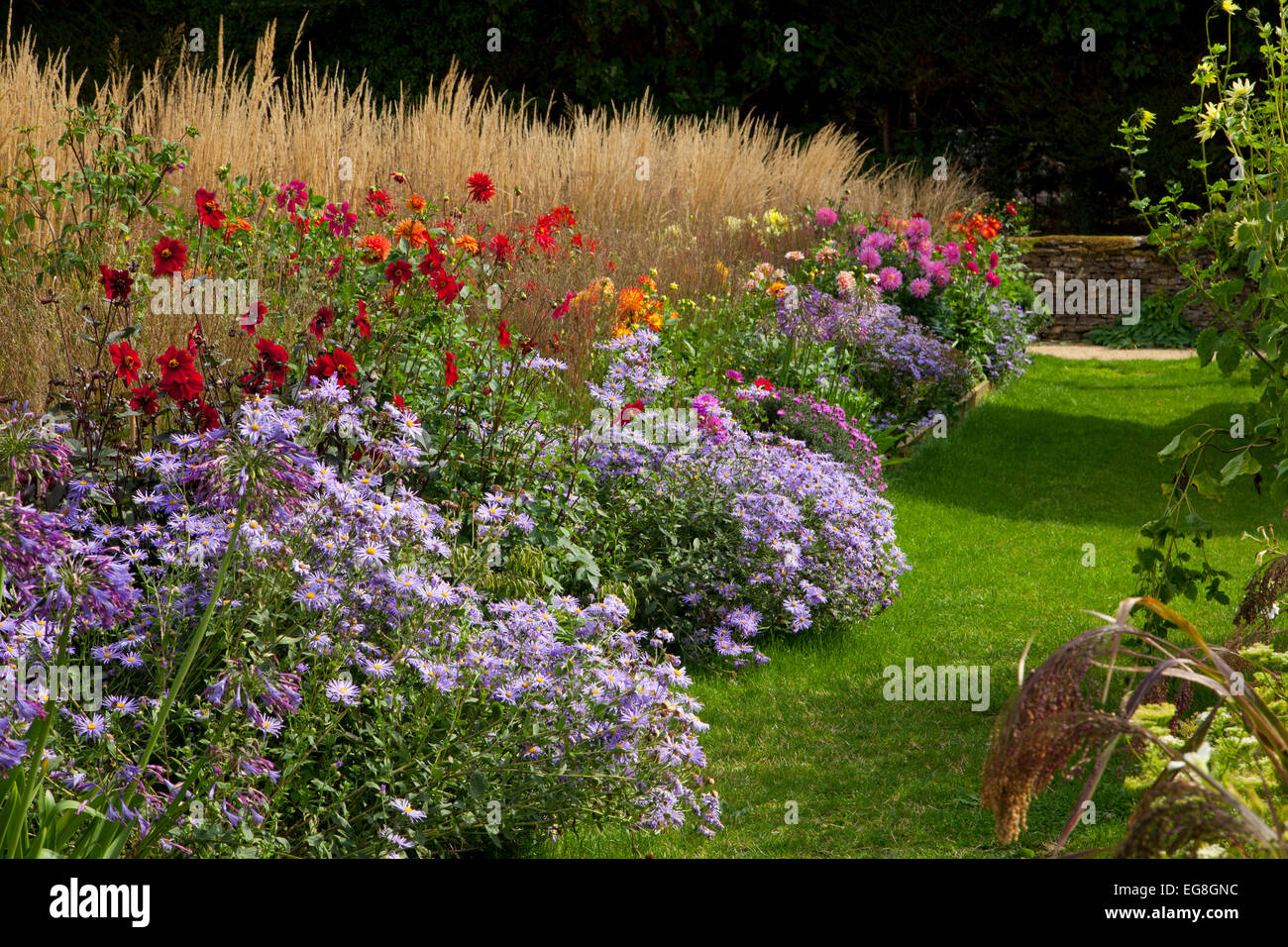Percorso di erba con inizio autunno Boarder nel Giardino Inglese,Oxfordshire,Inghilterra Foto Stock