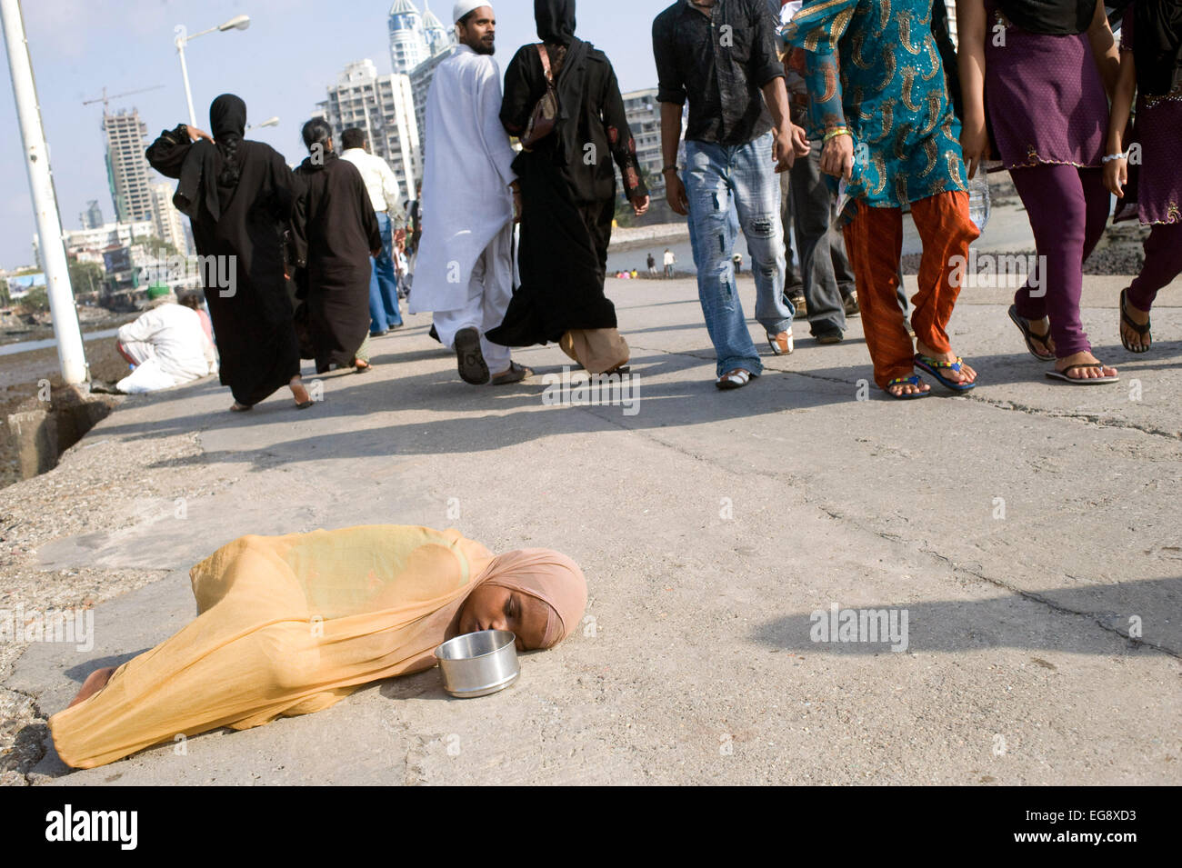 Mendicanti accumulato sulla causeway al Haji Ali moschea e Dargah , Mahalaxmi , Mumbai. Foto Stock