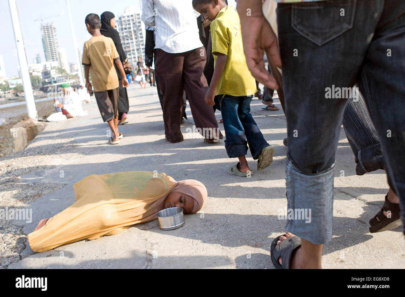 Mendicanti accumulato sulla causeway al Haji Ali moschea e Dargah , Mahalaxmi , Mumbai. Foto Stock