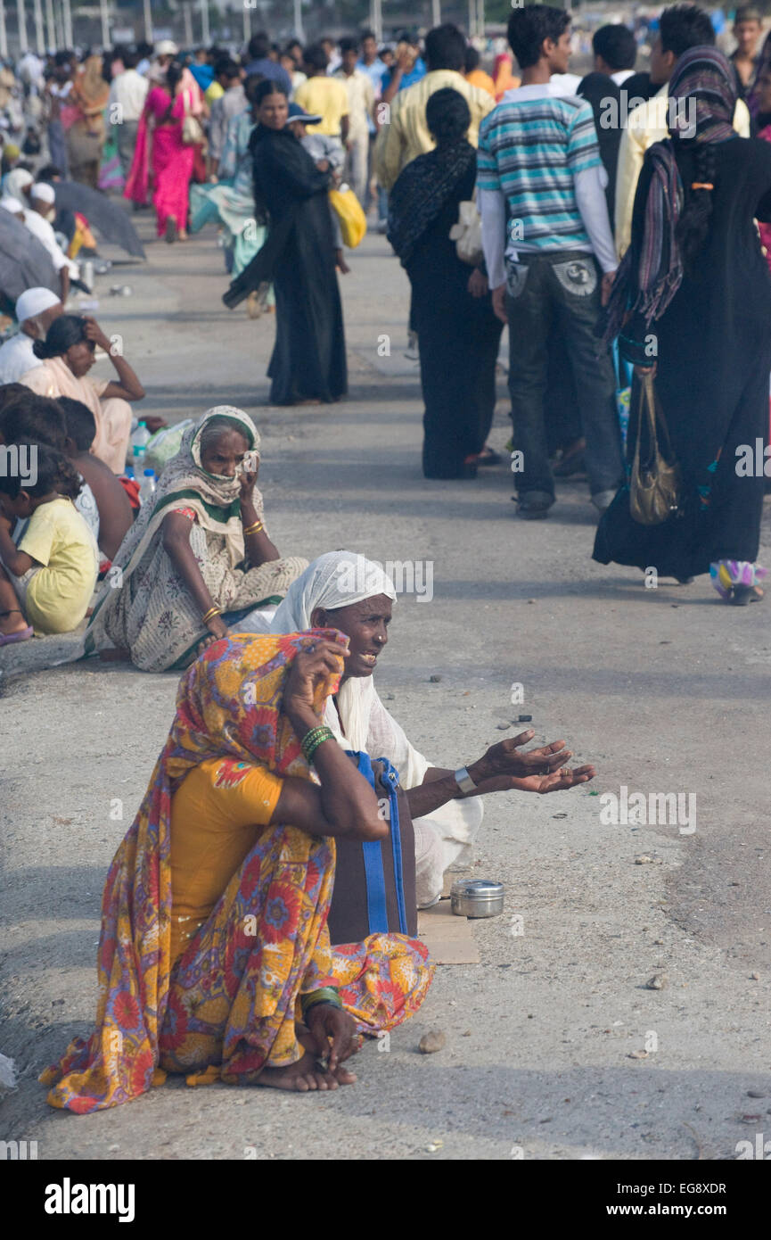 Mendicanti accumulato sulla causeway al Haji Ali moschea e Dargah , Mahalaxmi , Mumbai. Foto Stock