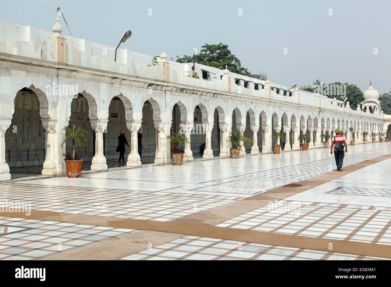 Uomo che cammina da archi, Gurudwara (tempio sikh) Bangla Sahib, New Delhi, India Foto Stock