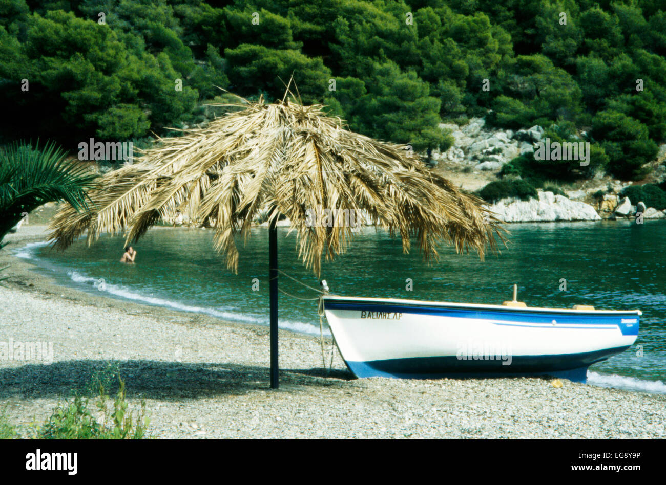 Barca sotto ombrellone in spiaggia greca in area Pelopponese Foto Stock