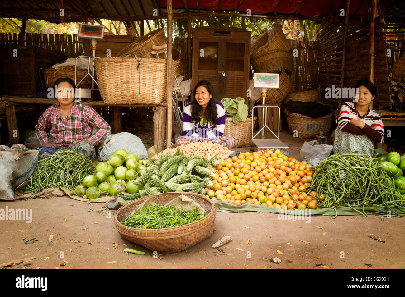 Donne birmane la vendita di cibo a loro stallo in un villaggio mercato, Bagan, Myanmar ( Birmania ), Asia Foto Stock