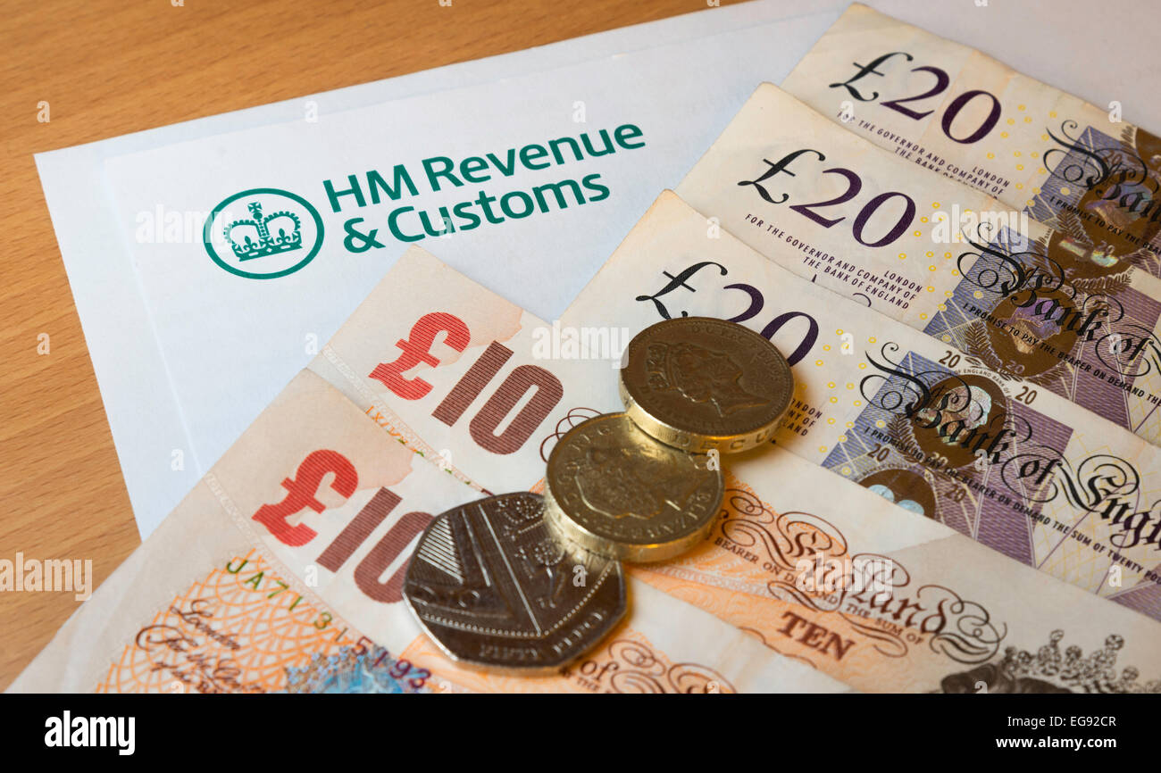 HMRC (Her Majesty's entrate e dogane) carta intestata su una scrivania circondata da denaro - sterline. Foto Stock