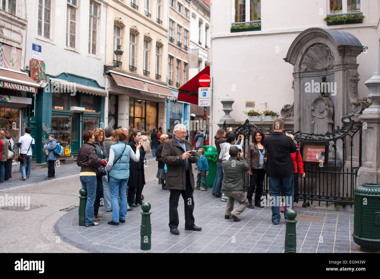 Persone provenienti da vedere la statua Manneken Pis Bruxelles Belgio Foto Stock