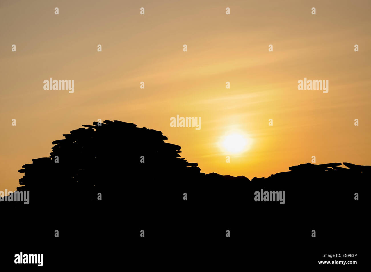 Profilo di un vecchio muro di pietra con il sole che tramonta dietro. Sulle colline sopra Glossop nel Derbyshire, Inghilterra. Foto Stock