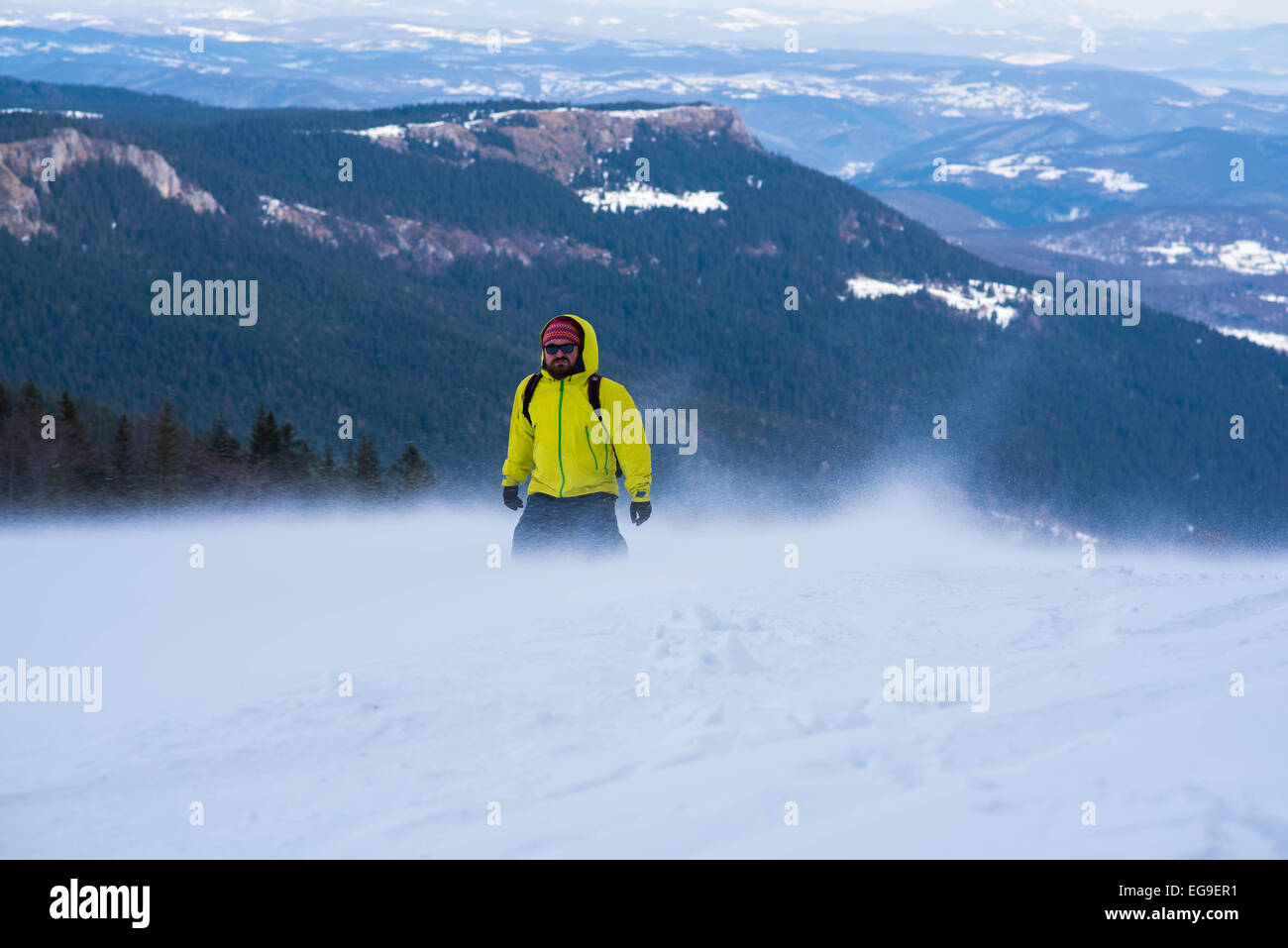 Uomo a camminare in montagna in inverno Foto Stock