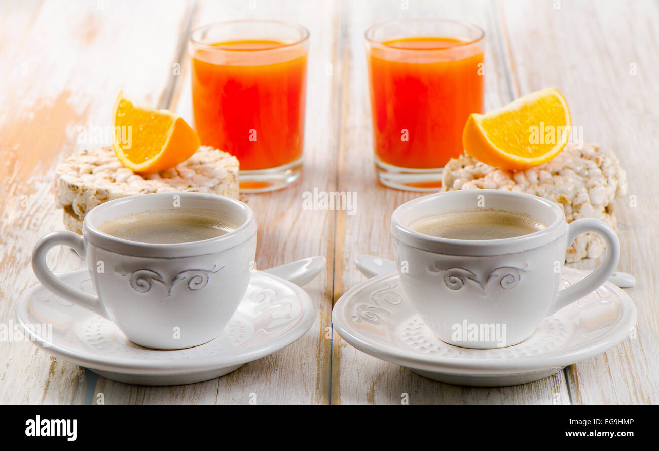 Una sana prima colazione - caffè, succo d'arancia e pane tostato bianco sul tavolo di legno. Foto Stock