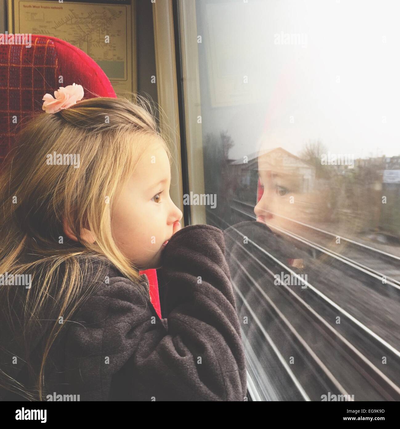 Ragazza cerca attraverso la finestra del treno Foto Stock