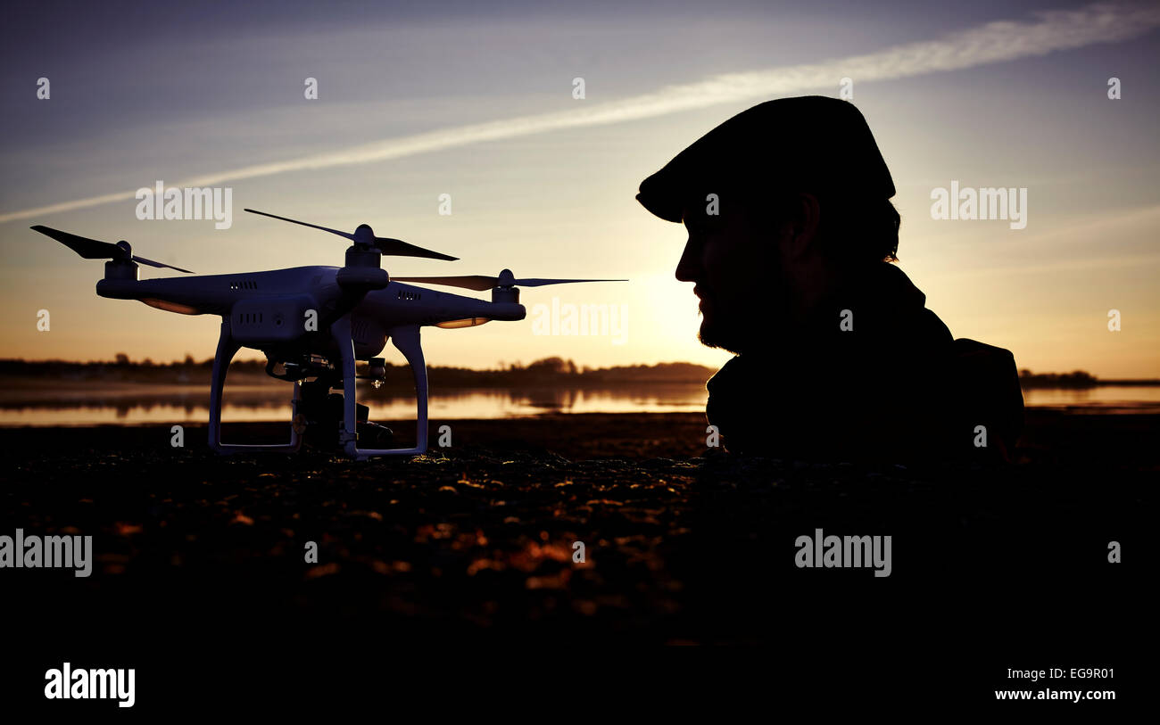 Stagliano l uomo al tramonto con un drone quadcopter Foto Stock