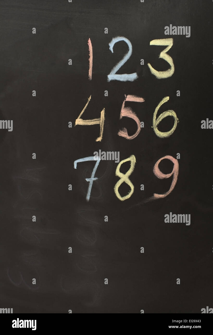 Numeri 1-9 in gesso colorato sulla lavagna. Foto Stock