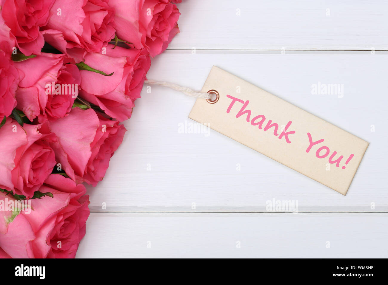 Le parole vi ringrazio con rose fiori su una tavola di legno sulla madre o il giorno di San Valentino Foto Stock