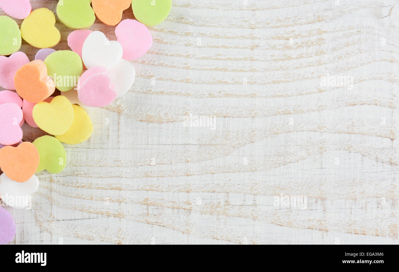 Scatto dall'alto di un gruppo di caramelle in colori pastello di San Valentino cuori nell'angolo superiore destro e il lato del telaio. Formato orizzontale o Foto Stock