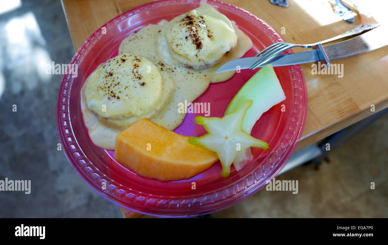 Uova Benedict con starfruit e papaya Foto Stock