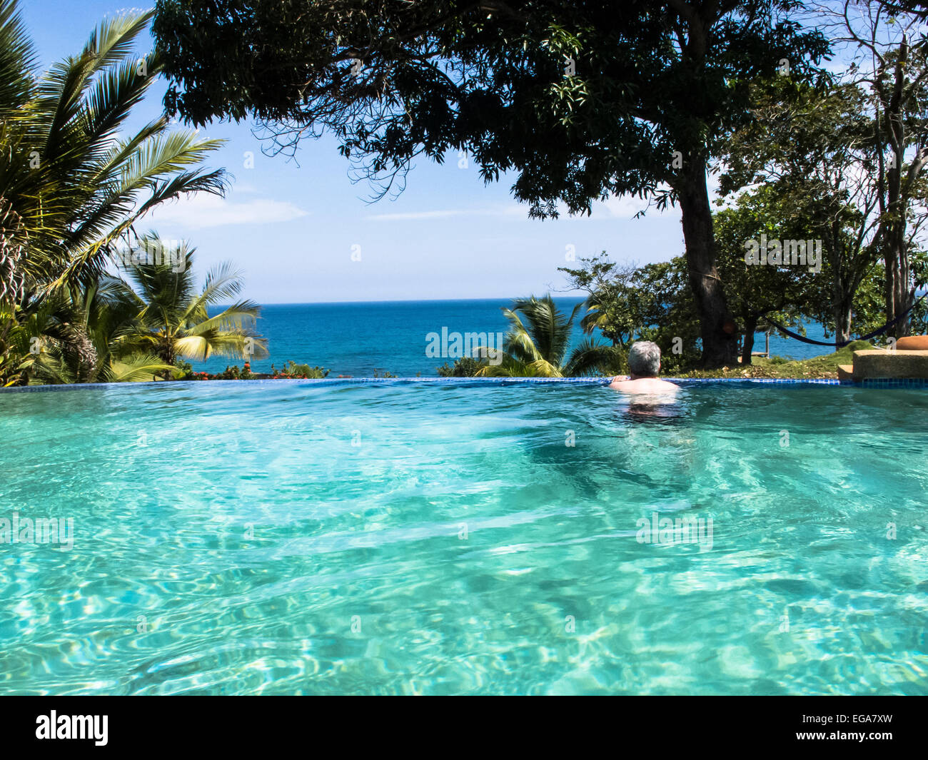 Un uomo nuotate nella piscina a sfioro di Lomas de Caruao lodge venezuelano. Foto Stock