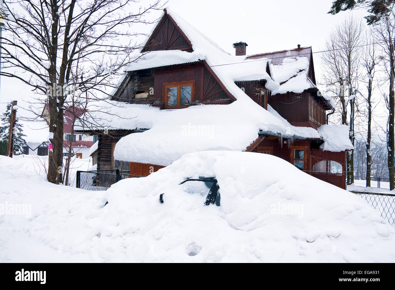 Casa e Auto sotto la neve nel villaggio di montagna il polacco Foto Stock