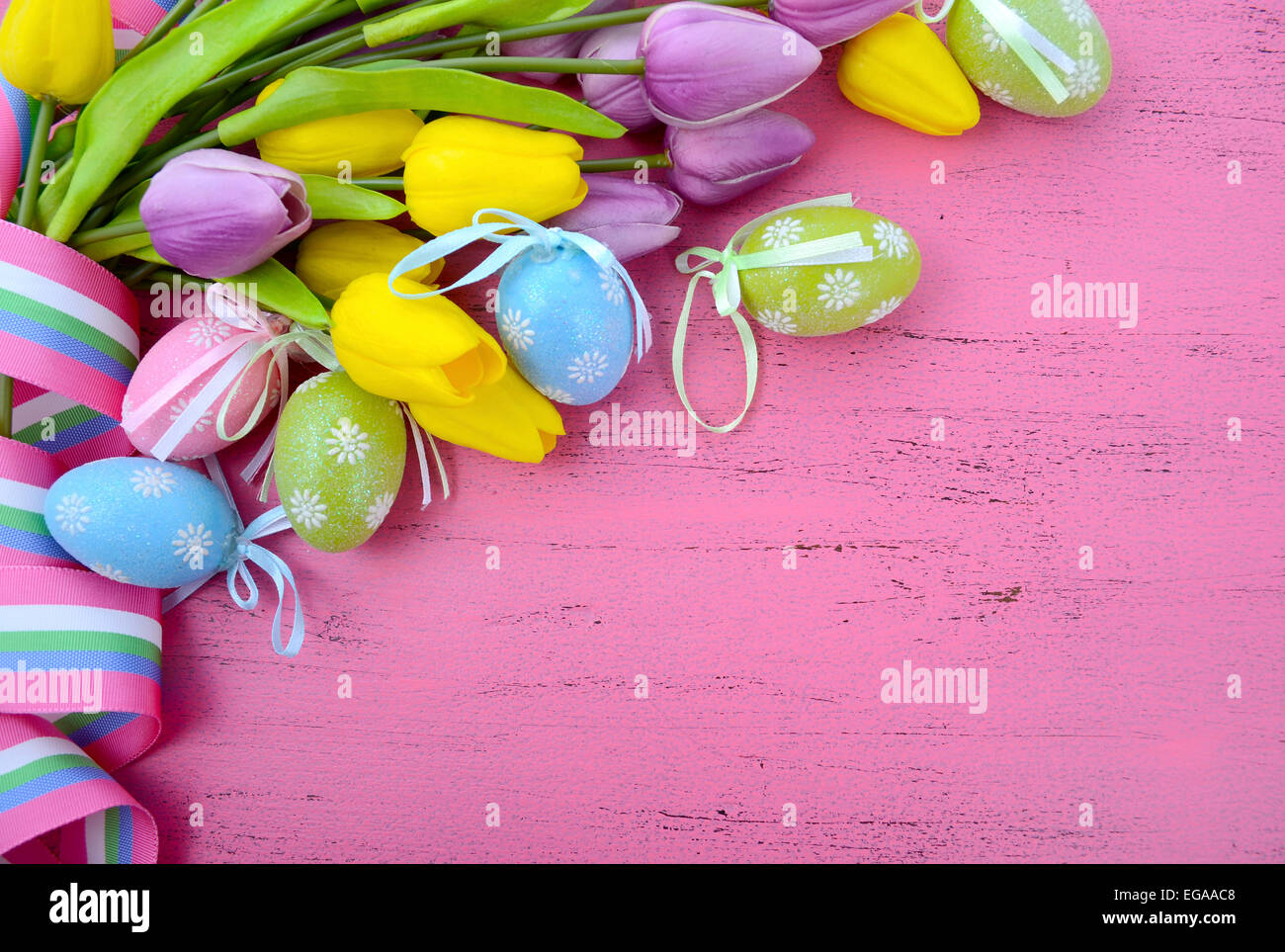 Felice Pasqua sfondo dipinto con le uova di Pasqua, giallo e viola i tulipani di seta e nastro su stile vintage rustico pi invecchiato Foto Stock