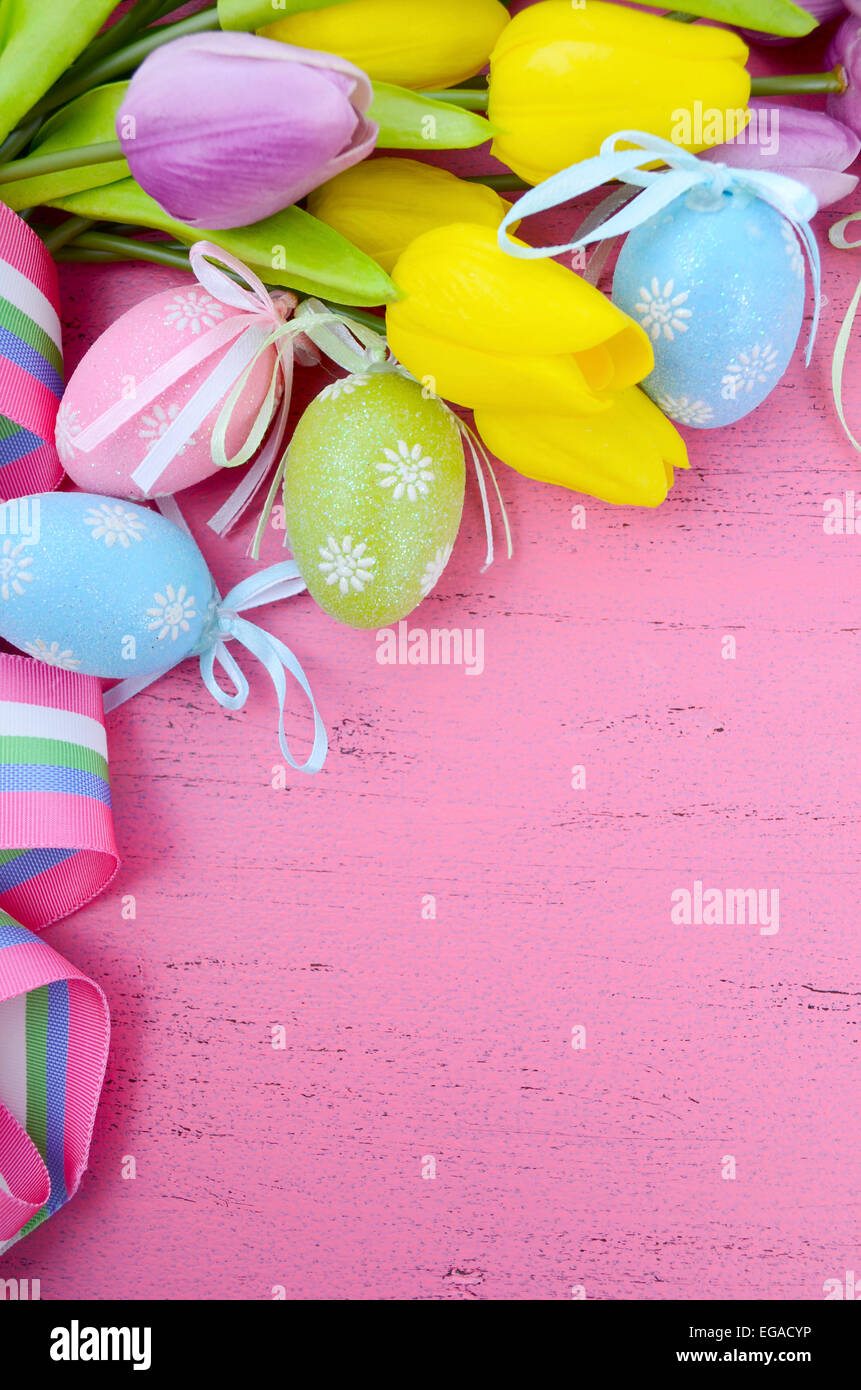 Felice Pasqua sfondo dipinto con le uova di Pasqua, giallo e viola i tulipani di seta e nastro su stile vintage rustico pi invecchiato Foto Stock