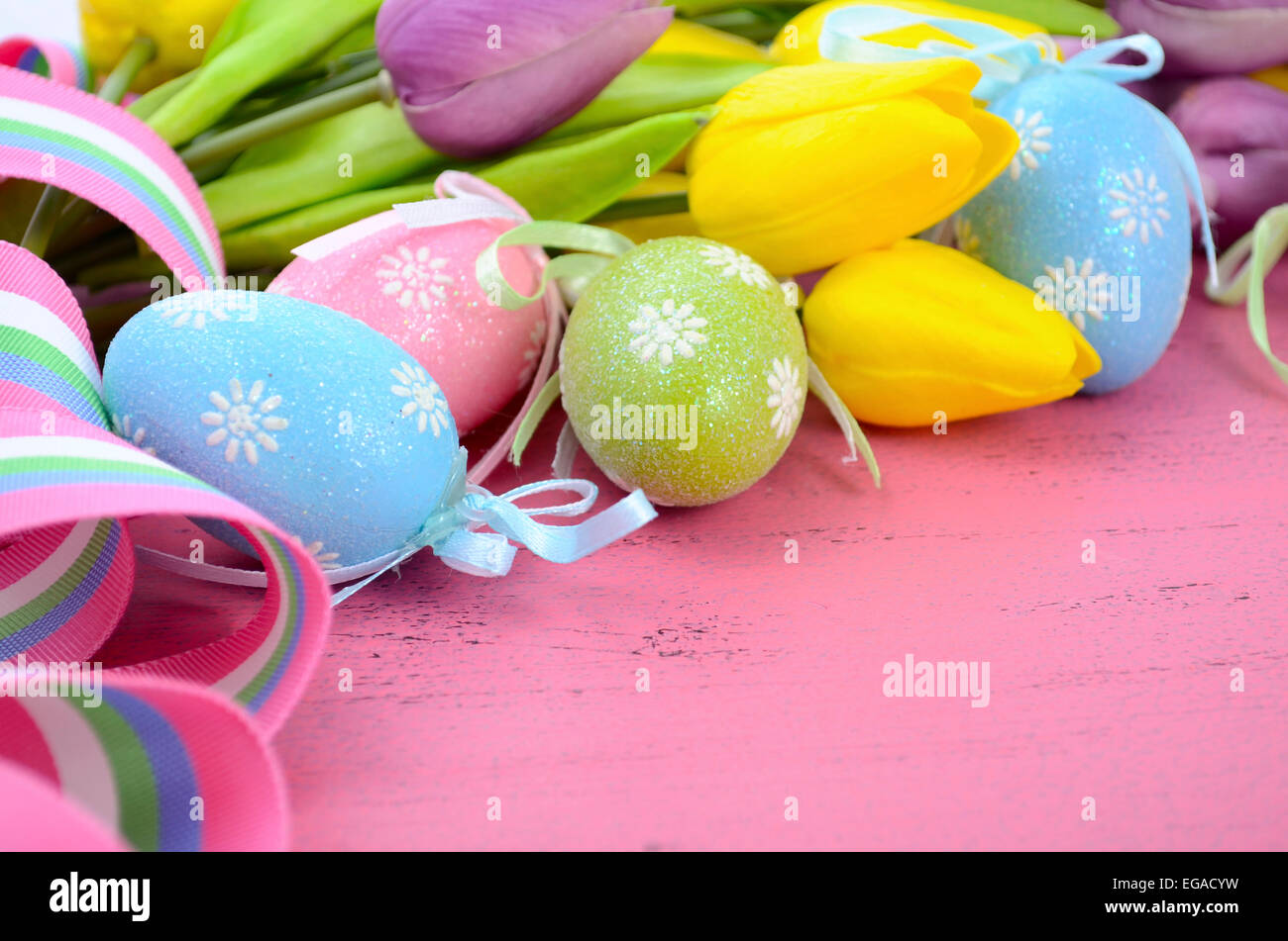 Felice Pasqua sfondo dipinto con le uova di Pasqua, giallo e viola i tulipani di seta e nastro su stile vintage rustico pi invecchiato Foto Stock