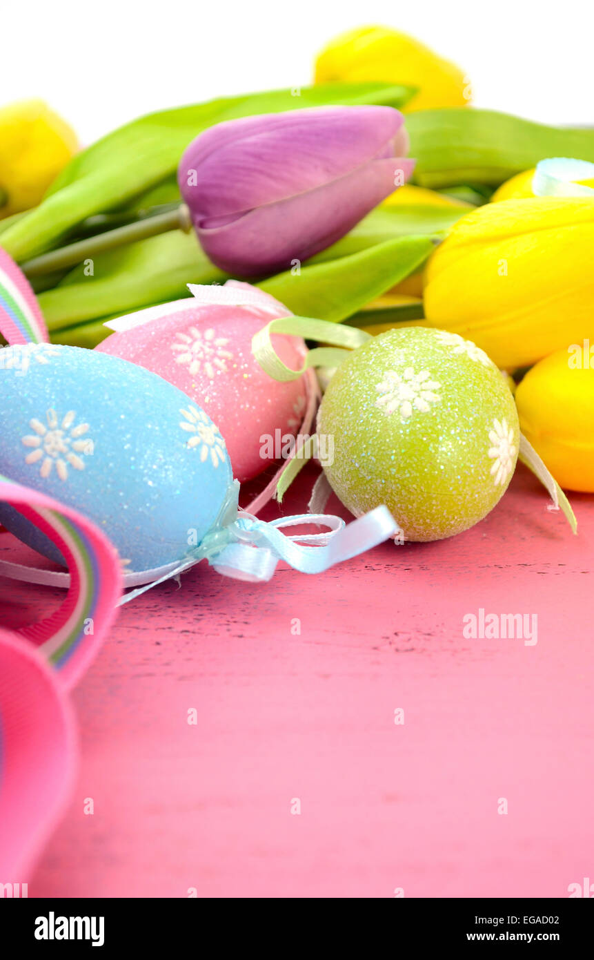Felice Pasqua sfondo dipinto con le uova di Pasqua, giallo e viola i tulipani di seta e nastro su stile vintage rustico pi invecchiato Foto Stock