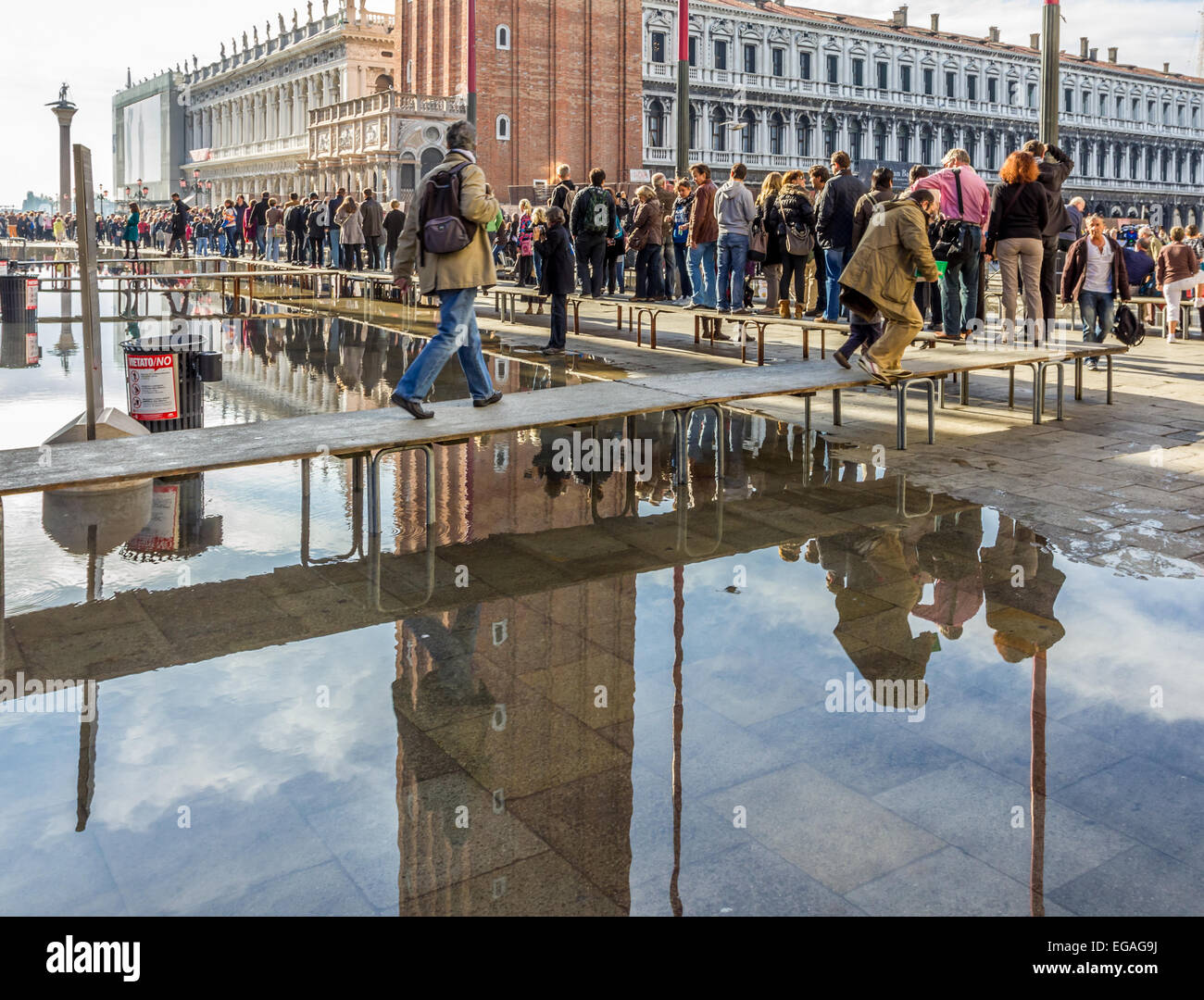 I turisti a piedi lungo percorsi sopraelevati durante le inondazioni (l'acqua alta in Piazza San Marco, Venezia Italia Foto Stock
