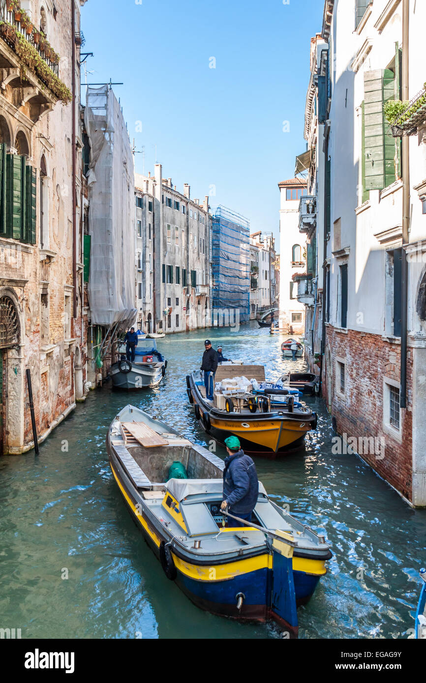 Due barche da lavoro navigare in un canale di Venezia Foto Stock