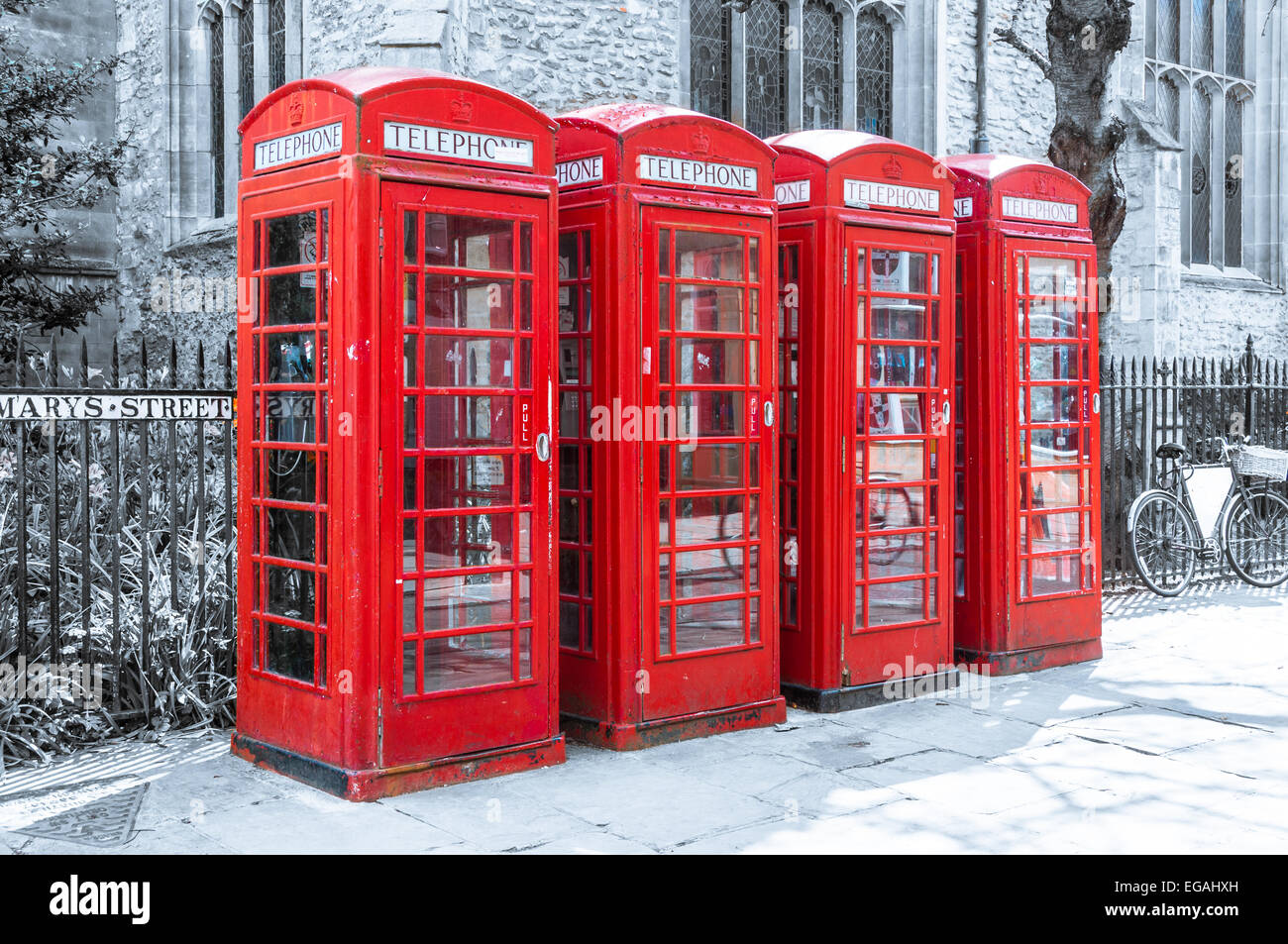 Fila di Red britannico le cabine telefoniche su sfondo dissaturata Foto Stock