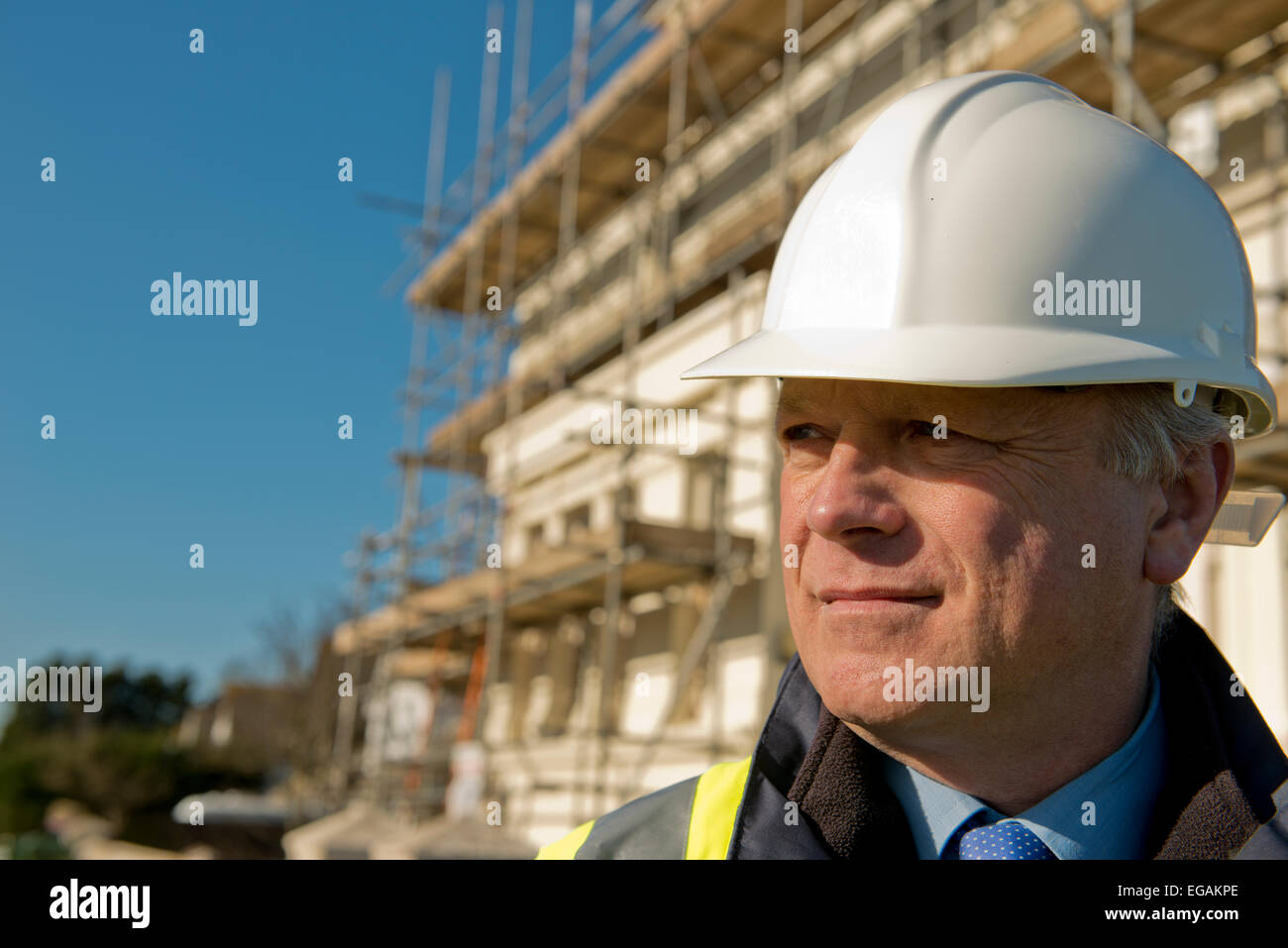 Ritratto di un sito in costruzione foreman,in piedi di fronte ad una nuova struttura integrata. Foto Stock