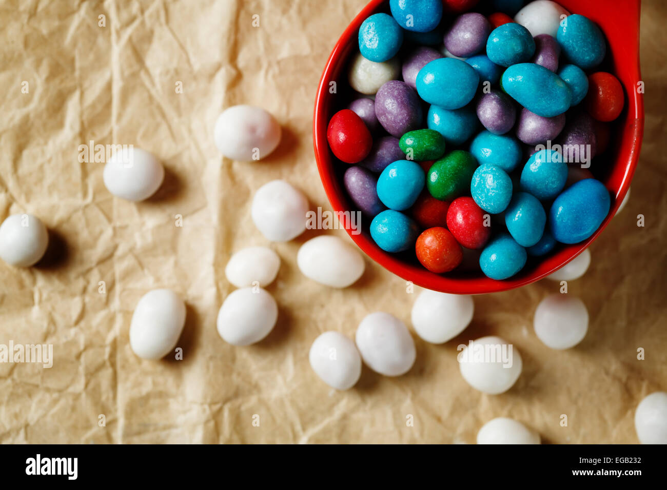 Poco caramelle colorate come ciottoli di mare sulle imbarcazioni di sfondo della carta. Holiday trattare. Foto Stock