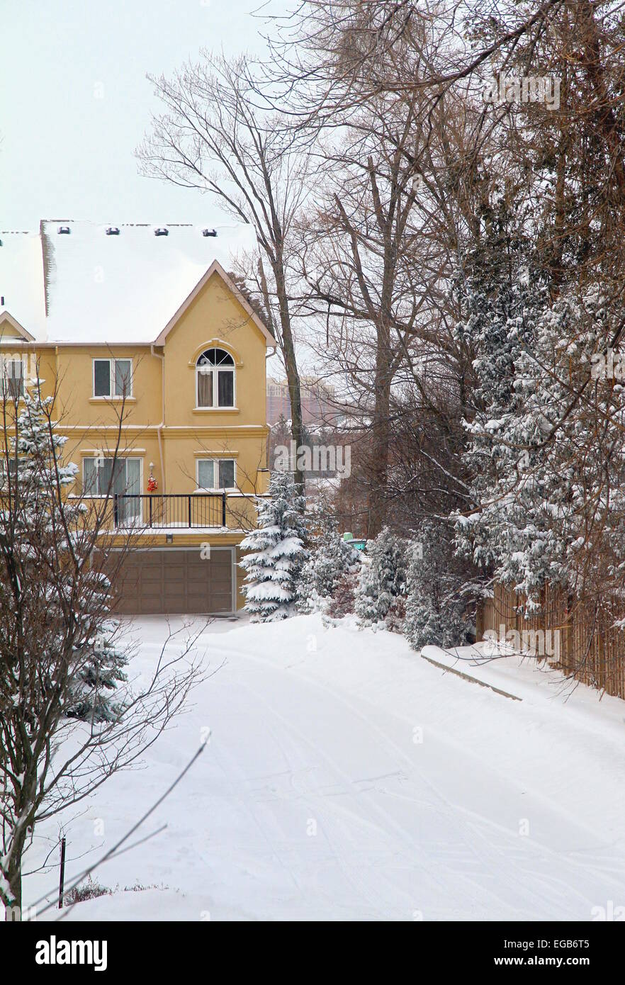 Coperta di neve su strada e case a schiera Foto Stock