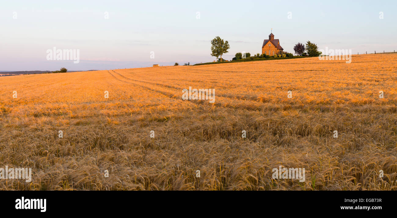 Una piccola cappella situata su di un colle a caldo della luce della sera nel nord Eifel in Germania. Foto Stock