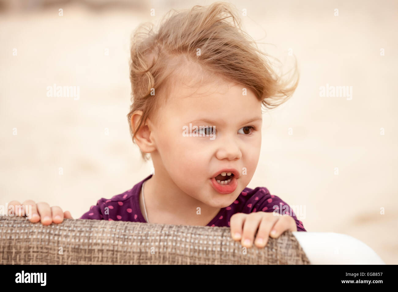 Outdoor closeup ritratto di carino bionda bambina con il vento tra i capelli Foto Stock
