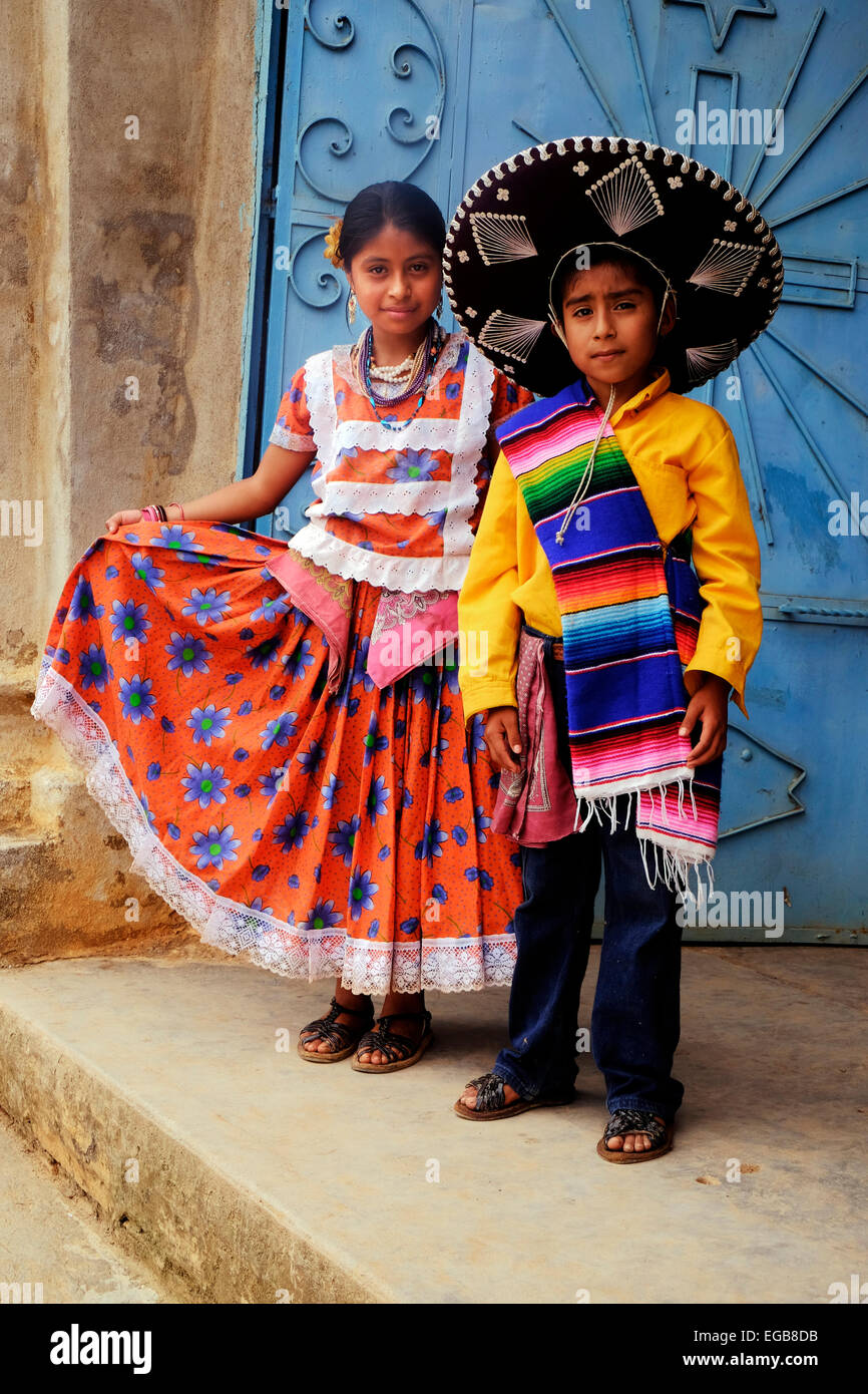 I giovani messicani danzatori Nativi pongono in una chiesa dorway nel villaggio di montagna di Yagavila in stato di Oaxaca in Messico. Foto Stock