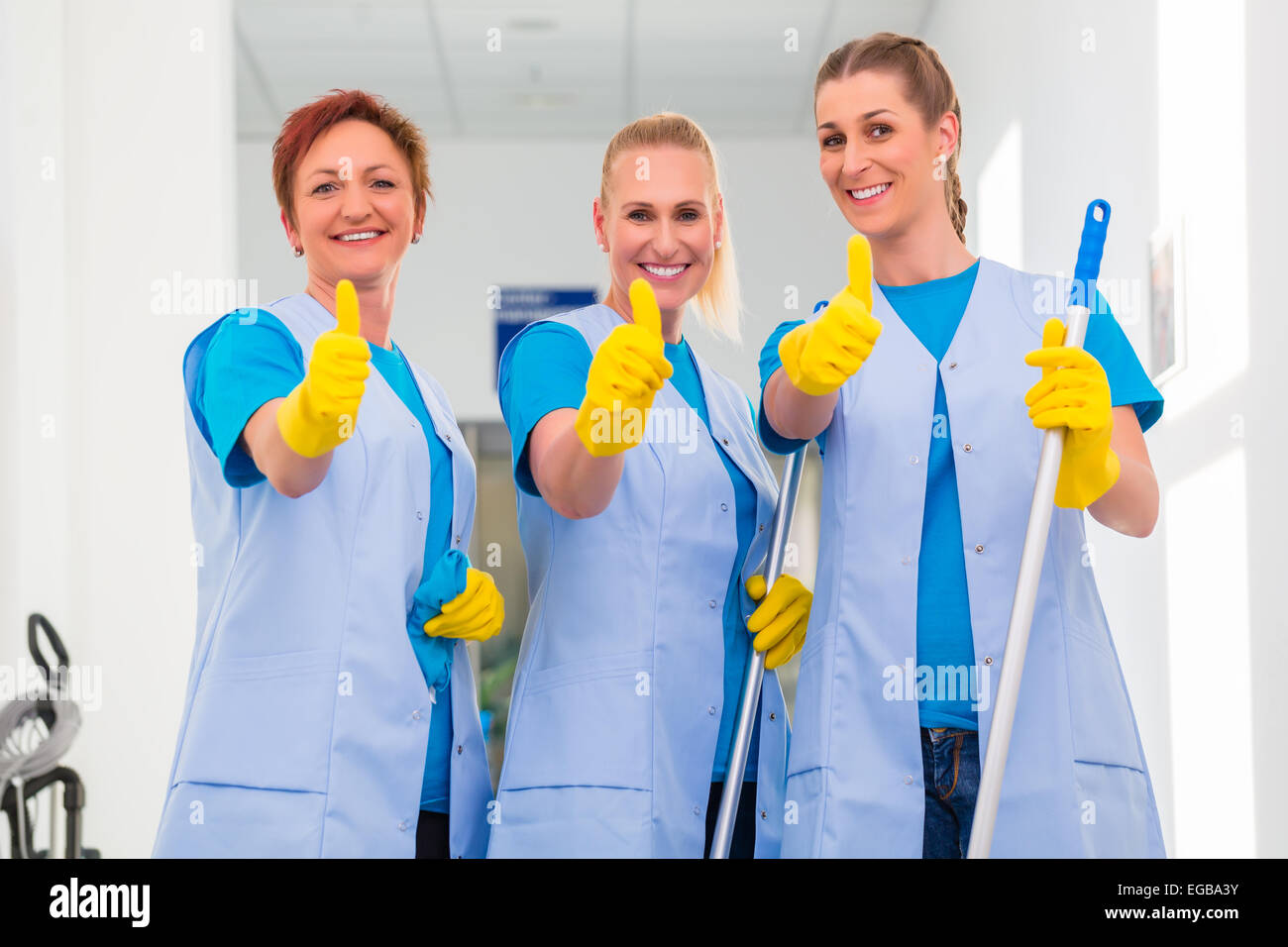 Le donne delle pulizie che lavorano in team che mostra il pollice in alto segno Foto Stock