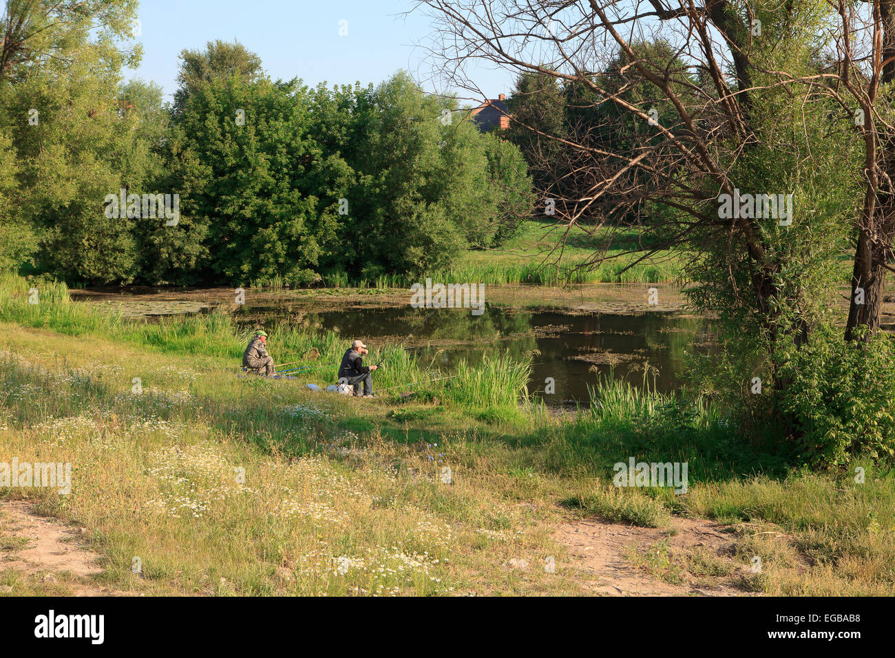 Due pescatori pesca al fiume Kolomenka appena fuori la velocità pista di pattinaggio in Kolomna, Russia Foto Stock