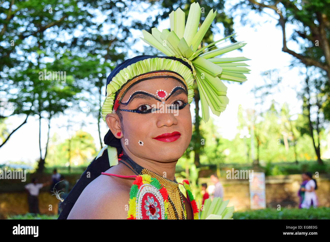 Il ragazzo nativo di eseguire folk tradizionale arte rituale nel Festival di Onam processione in Kerala India con espressione facciale in costume Foto Stock