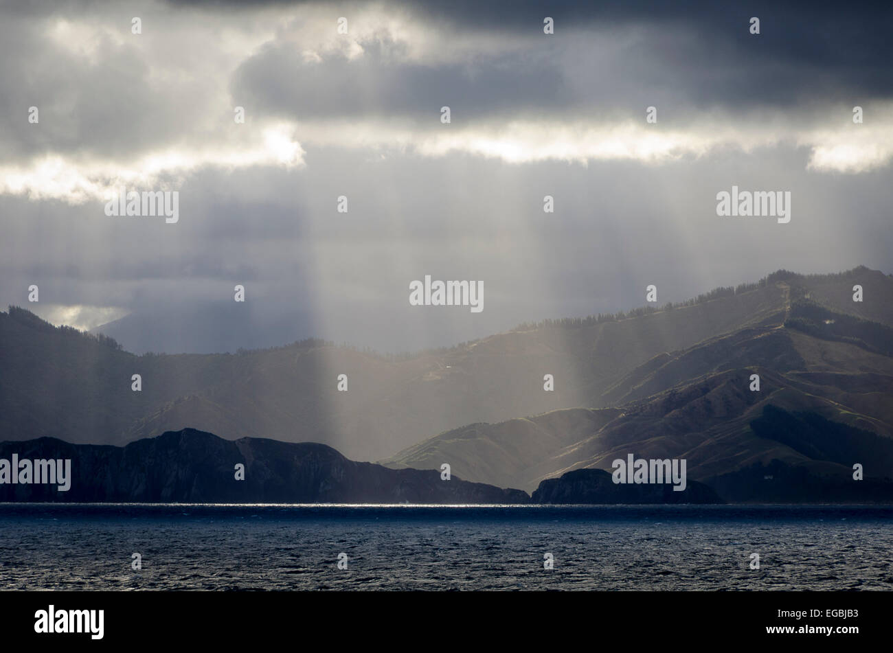 Sole che splende attraverso le nuvole, stretto di Cook all'entrata di Marlborough Sounds, Isola del Sud, Nuova Zelanda Foto Stock